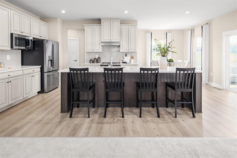 105 Ripplemead Court Gallatin, TN 37066 - Photo 2 of 21 a kitchen with stainless steel appliances granite countertop a dining table chairs refrigerator microwave and cabinets