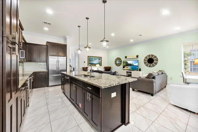 a kitchen with granite countertop a sink and a refrigerator
