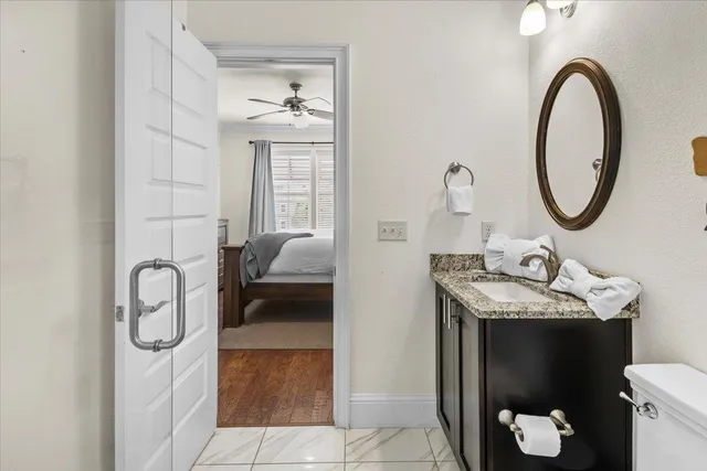 a en suite bathroom with a granite countertop sink and a mirror