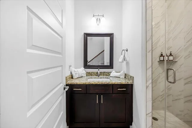 a bathroom with a granite countertop sink and a mirror