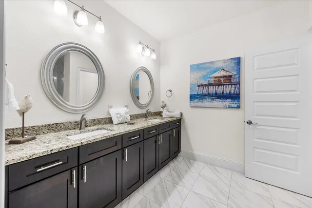 a bathroom with a granite countertop double vanity sink and a mirror