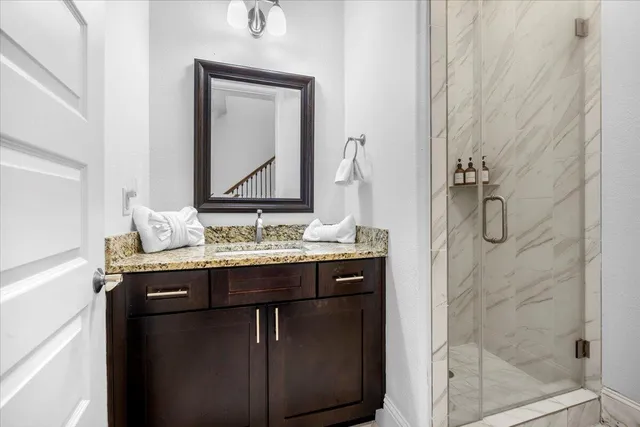 a bathroom with a granite countertop sink a toilet and shower
