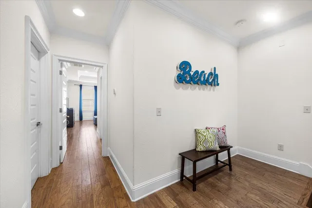 a view of a hallway with wooden floor and a workspace