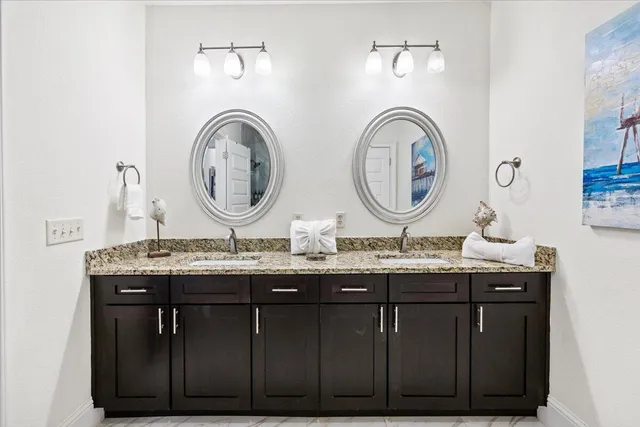 a bathroom with a granite countertop two sink and a mirror