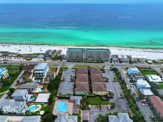 an aerial view of a city with lots of residential buildings ocean and mountain view in back