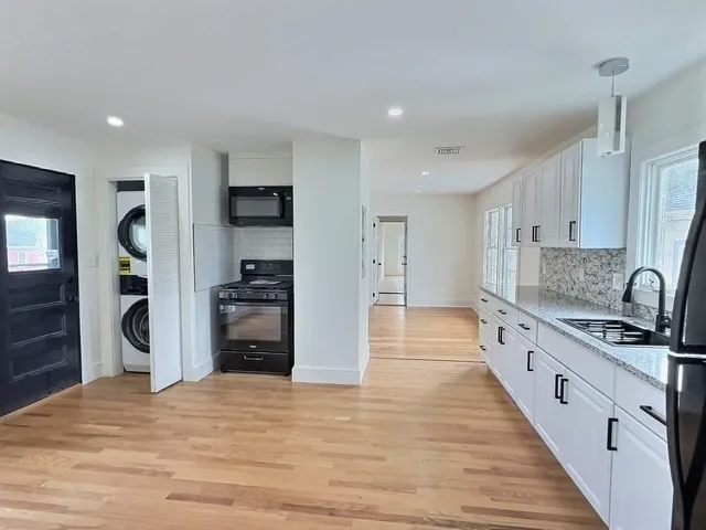 a kitchen with stainless steel appliances granite countertop a refrigerator and a stove top oven
