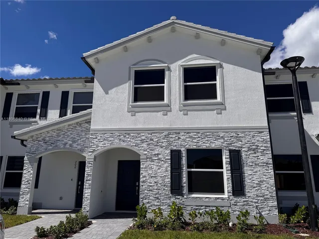 a front view of a house with plants
