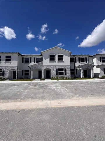 a view of a house with a yard in the background