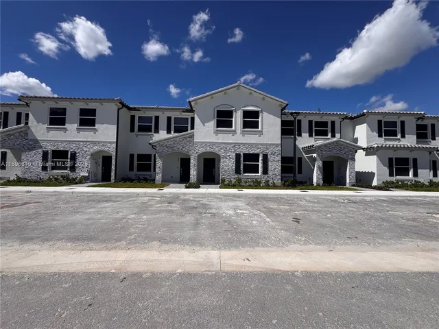 a large white house with a large parking space and a street view