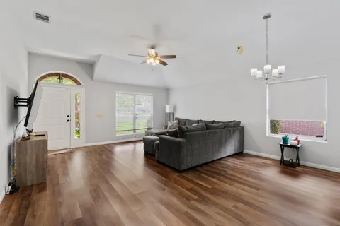 a living room with furniture and a wooden floor