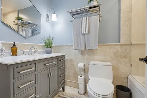 a bathroom with a granite countertop toilet sink and mirror