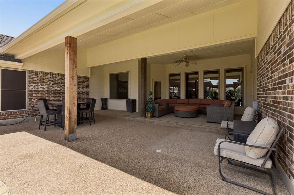 317 Singing Quail Trail Haslet, TX 76052 - Photo 25 of 32 Spacious covered patio featuring exposed aggregate flooring, brick facade, recessed lighting, and a ceiling fan