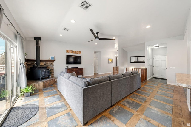 7776 Wagon Road East St. George, UT 84770 - Photo 9 of 76 Living room featuring a wood stove, a ceiling fan, recessed lighting, and stone finish floors