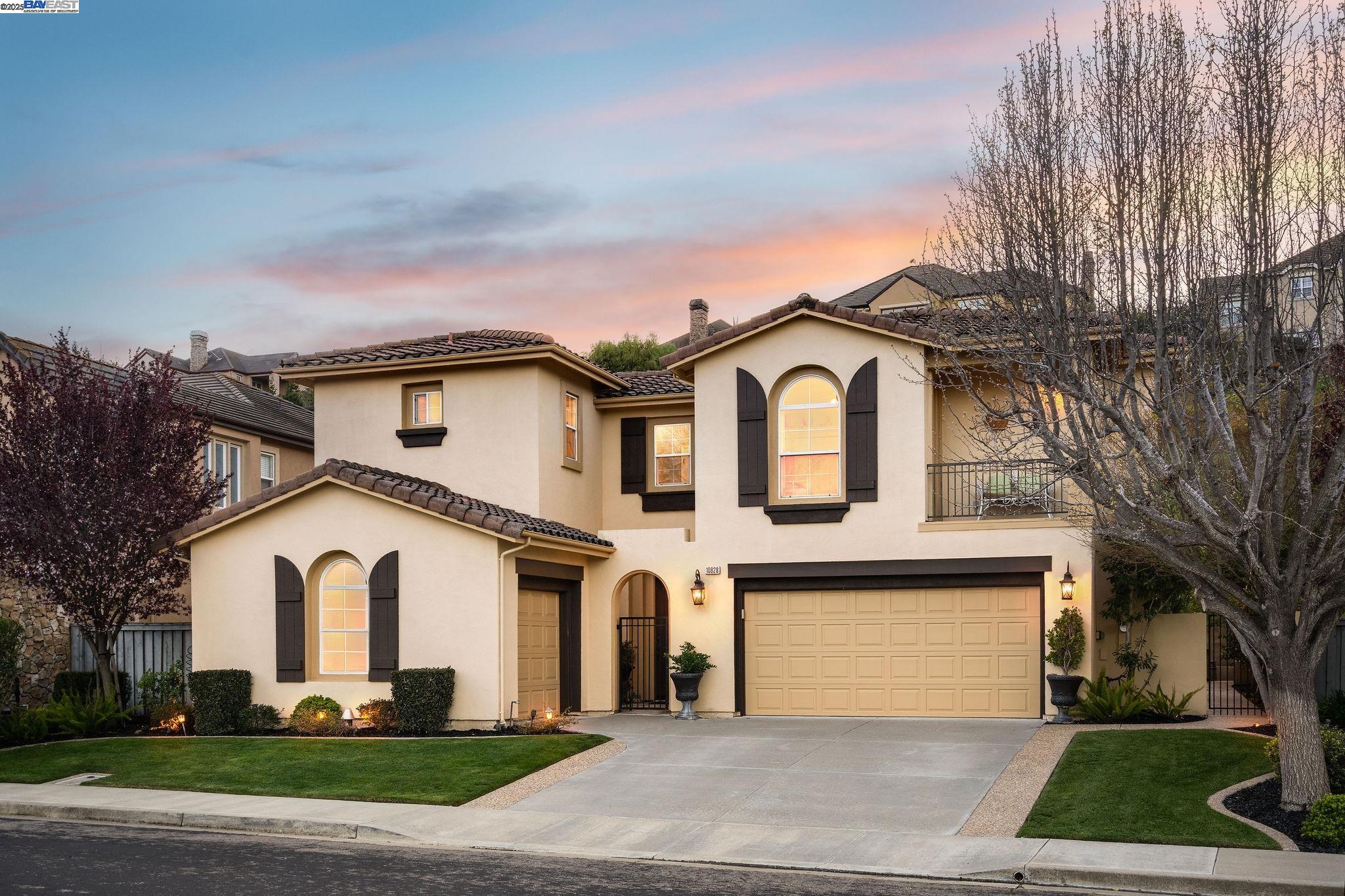 a front view of a house with a garden and trees