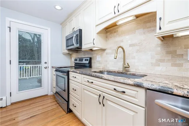 a kitchen with stainless steel appliances granite countertop a sink and a stove
