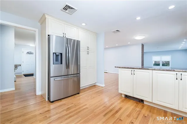 a kitchen with white cabinets and stainless steel appliances