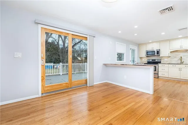 a view of a kitchen with wooden floor and a sink