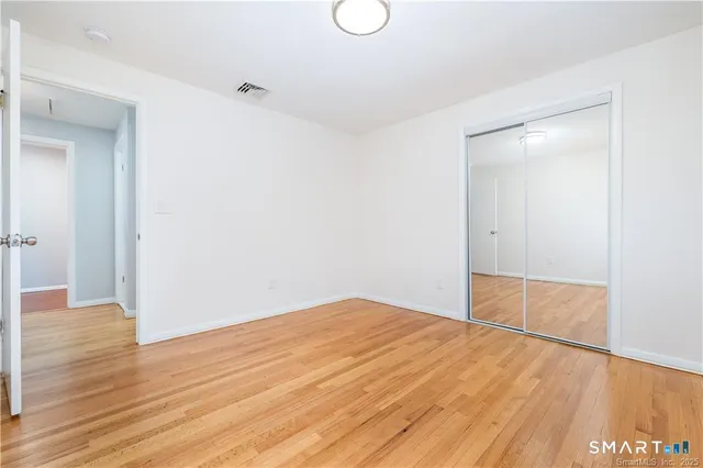 a view of empty room with wooden floor