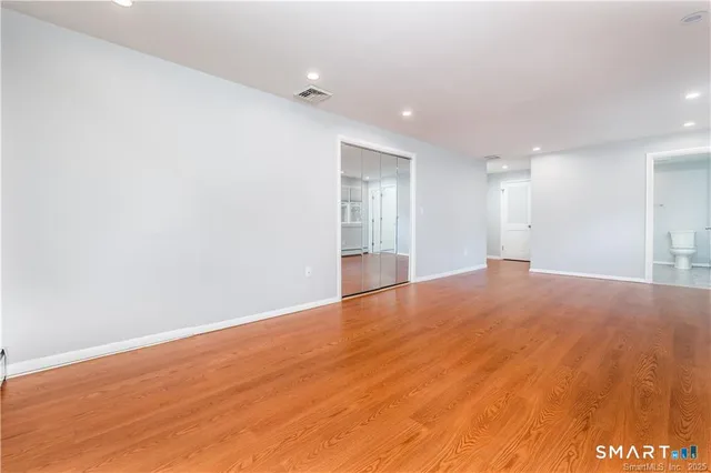 a view of empty room with wooden floor