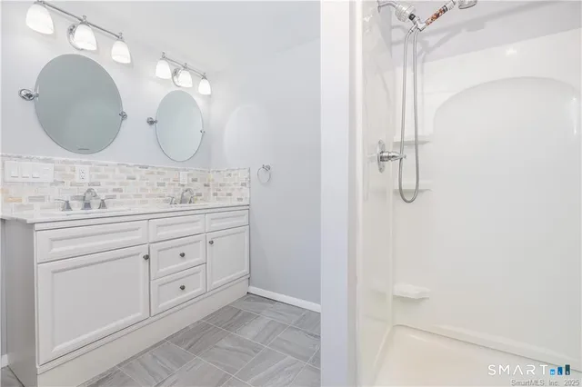 a bathroom with a double vanity sink and a mirror