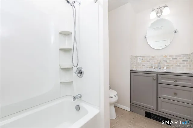 a bathroom with a granite countertop sink mirror and a bathtub
