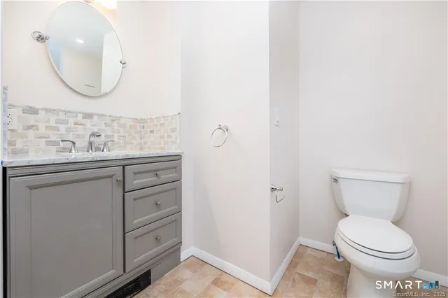 a bathroom with a toilet a sink and mirror