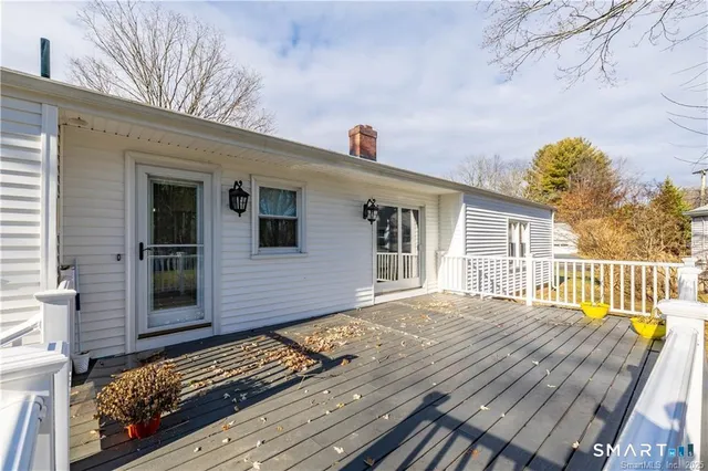 a view of deck and trees with wooden fence and floor