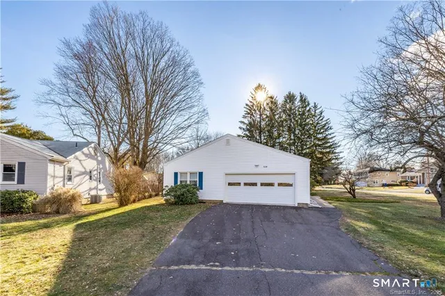 a view of a white house with a yard next to a yard