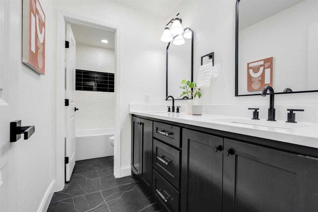 9376 Briarhurst Drive Dallas, TX 75243 - Photo 28 of 38 a bathroom with a double vanity sink a mirror and shower