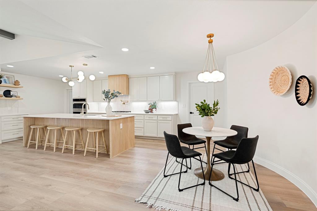 9376 Briarhurst Drive Dallas, TX 75243 - Photo 6 of 38 a kitchen with kitchen island a dining table and chairs