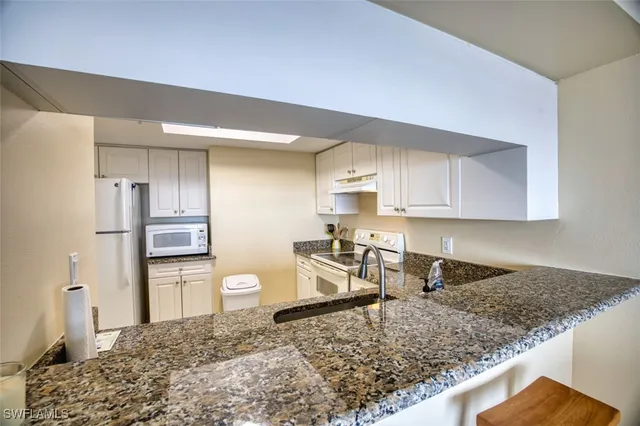 a kitchen with a refrigerator sink stove and cabinets