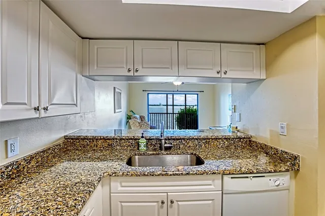 a kitchen with granite countertop a counter top space cabinets and stainless steel appliances