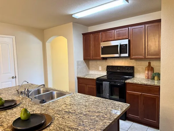 a kitchen with stainless steel appliances granite countertop a stove and a microwave