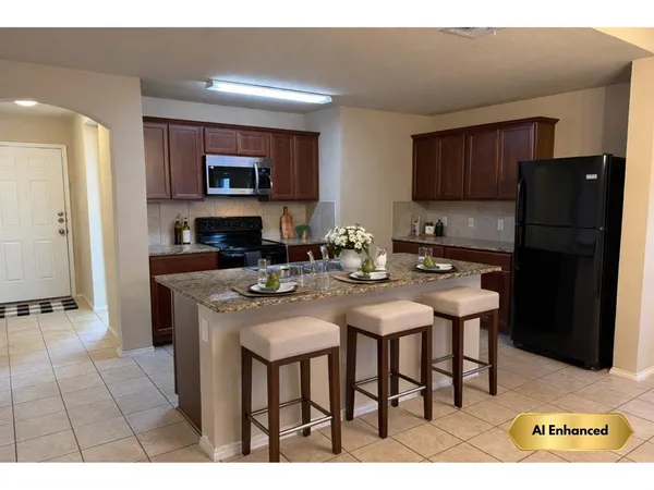 a kitchen with stainless steel appliances granite countertop a sink refrigerator and cabinets