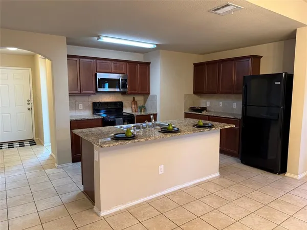 a kitchen with stainless steel appliances granite countertop a refrigerator stove and a sink