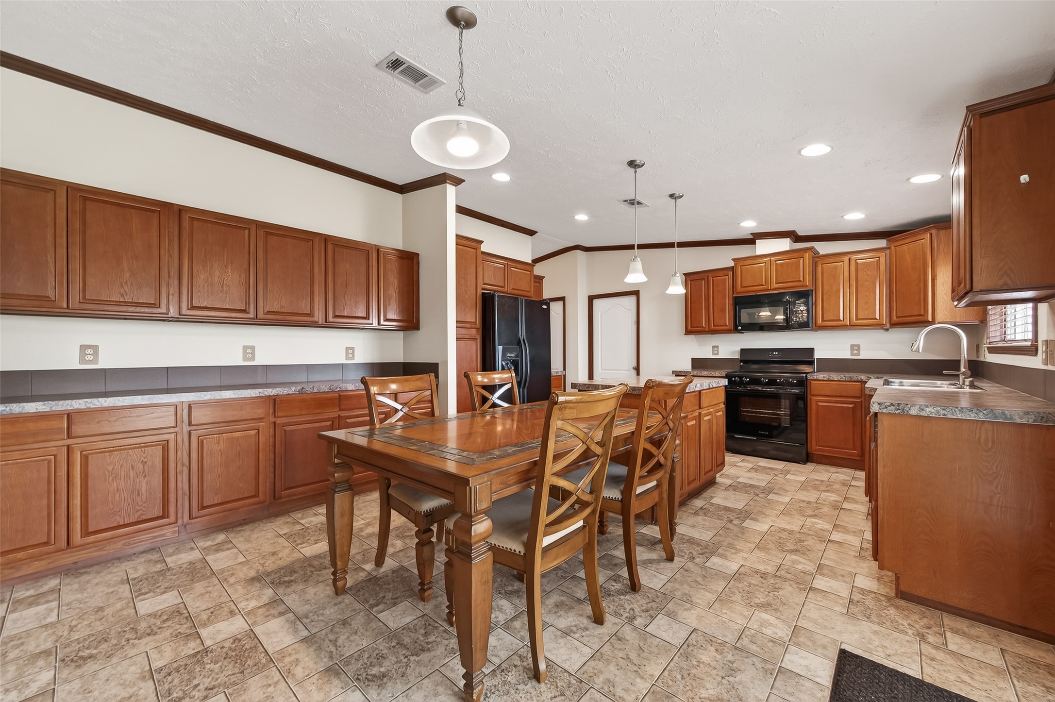 9820 Oberrender Road Needville, TX 77461 - Photo 11 of 30 a kitchen with stainless steel appliances granite countertop a table chairs sink and cabinets