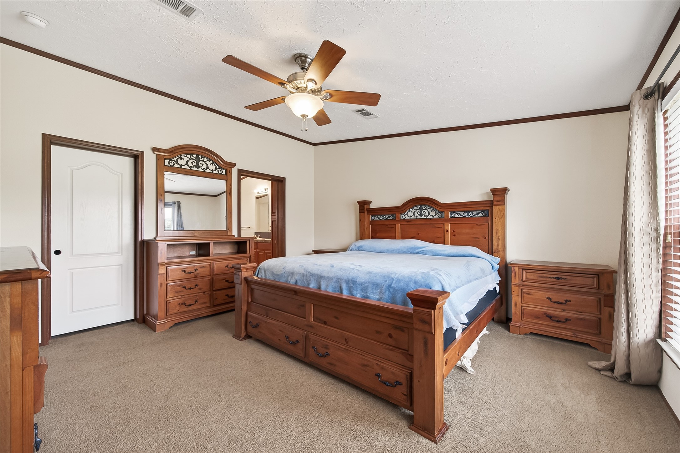 9820 Oberrender Road Needville, TX 77461 - Photo 18 of 30 a bedroom with a bed and a chandelier