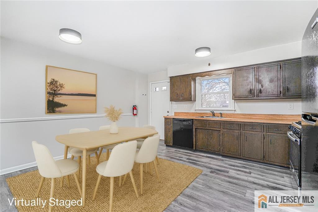 1036 Apache Street, Unit B North Brunswick, NJ 08902 - Photo 7 of 26 a kitchen with granite countertop a table chairs stove and wooden floor