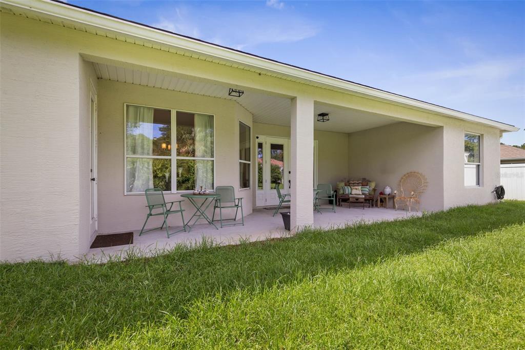20 Rybar Lane Palm Coast, FL 32164 - Photo 29 of 40 a view of a patio with table and chairs with plants and wooden fence