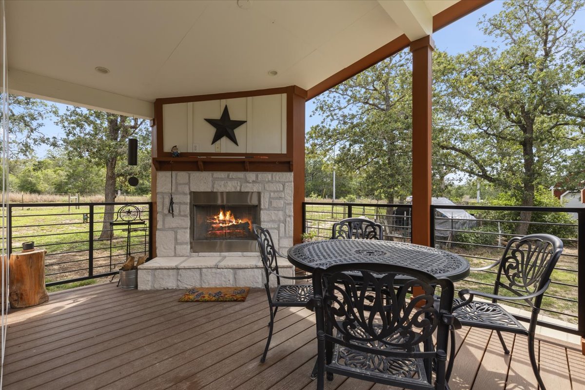 1705 Makinson Road West Point, TX 78963 - Photo 11 of 40 An inviting outdoor patio, perfect for relaxing evenings by the fireplace, overlooks a serene natural landscape.