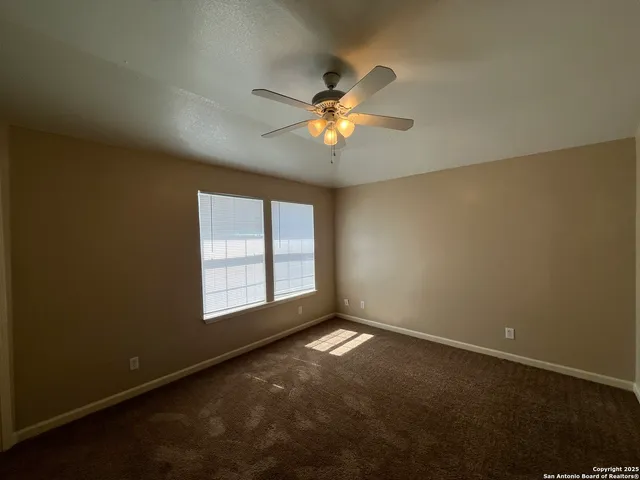 a view of a room with windows and chandelier fan