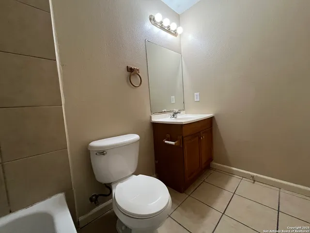 a bathroom with a toilet a sink and mirror