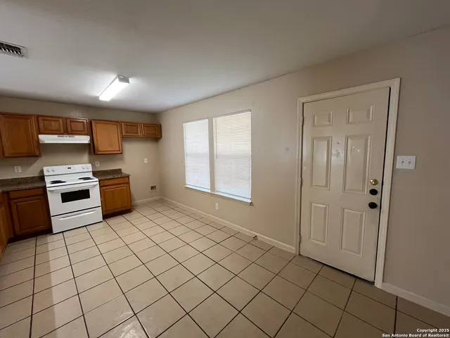 a kitchen with stainless steel appliances a sink a stove a refrigerator and cabinets