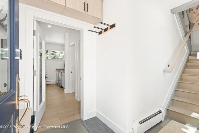 a view of a hallway with wooden floor and staircase