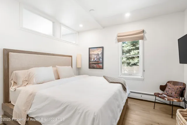 a bedroom with a bed and wooden floor