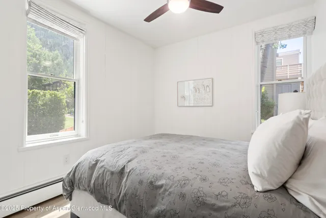 a view of a bedroom with wooden floor and a window