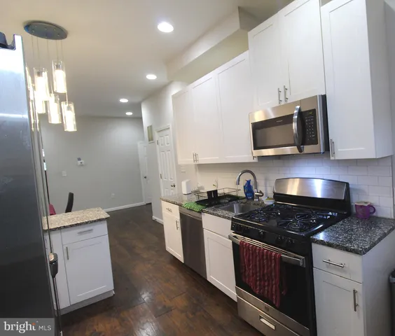 a kitchen with a sink stove and microwave