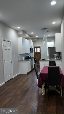 a living room with stainless steel appliances kitchen island granite countertop furniture and wooden floor