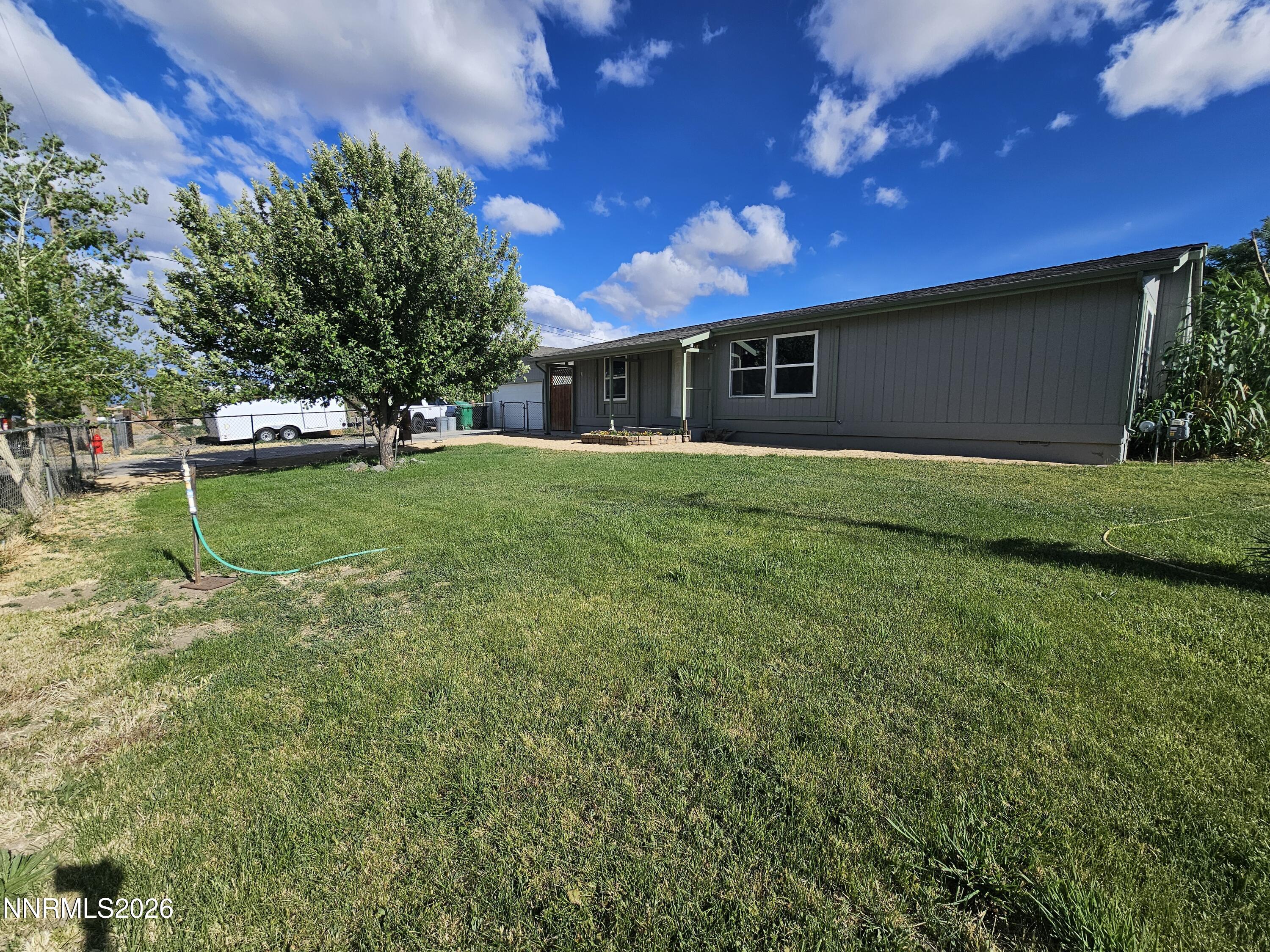 1125 Rancho Road Fernley, NV 89408 - Photo 3 of 47 a view of a backyard with plants and a bench