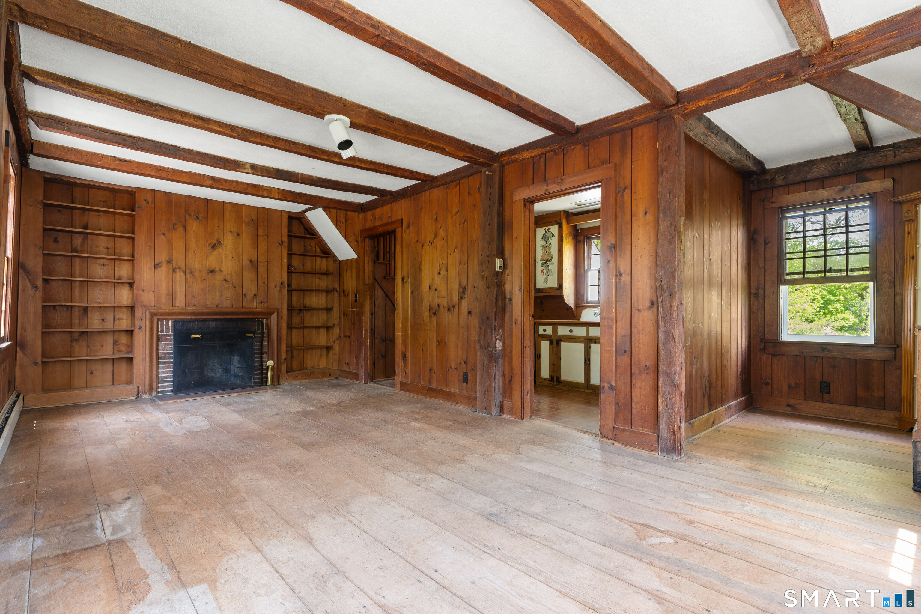 93 Upton Road Ashford, CT 06278 - Photo 34 of 40 90 Upton Road - Showcasing exposed beams, hardwood floors, built-in bookcases, fireplace, open living/dining layout, & main level kitchen.